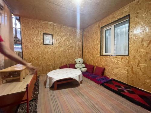 a living room with a couch and a teddy bear at SIA Guest House in Naryn