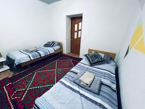 a bedroom with two beds and a door at SIA Guest House in Naryn