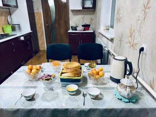a table with food and bowls of fruit on it at SIA Guest House in Naryn