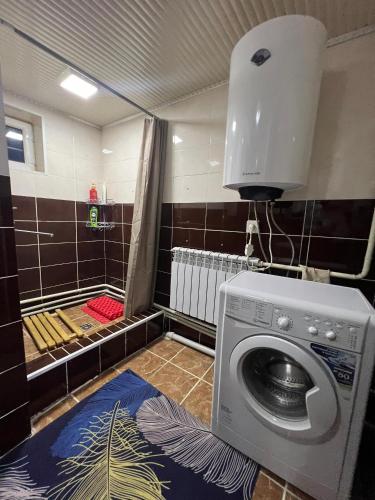 a bathroom with a washing machine in a room at SIA Guest House in Naryn