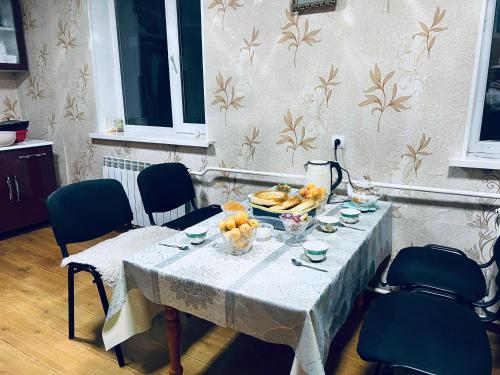 a table with a bowl of fruit on it at SIA Guest House in Naryn