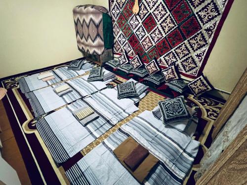 a bed with pillows on top of it next to a wall at SIA Guest House in Naryn