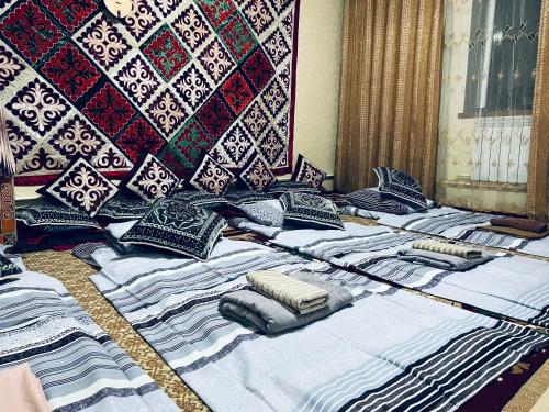 a group of pillows on a bed in a room at SIA Guest House in Naryn