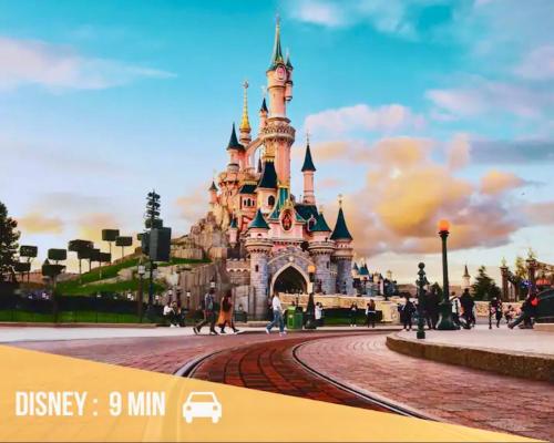 Un château disney avec des gens qui marchent autour de lui dans l'établissement Studio 2 adultes 2 enfants parcs Disneyland Paris, à Montévrain