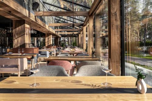 a restaurant with tables and chairs and windows at Verholy Relax Park in Sosnovka