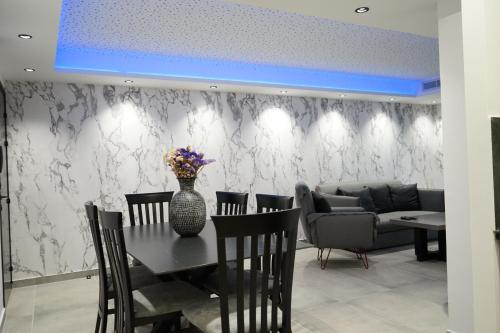 a dining room with a table and chairs and a couch at Lazuli Urban Luxury -2 bedroom with Pool in Larnaka