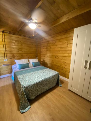 a bedroom with a bed in a room with wooden walls at Casas ROBRA in El Palmar
