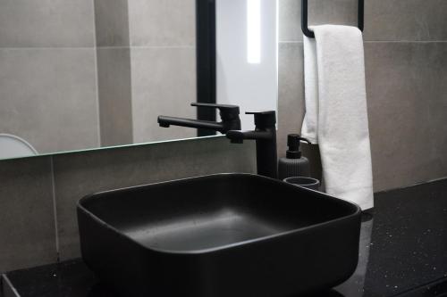 a bathroom with a black sink and a mirror at Lazuli Urban Luxury -2 bedroom with Pool in Larnaka