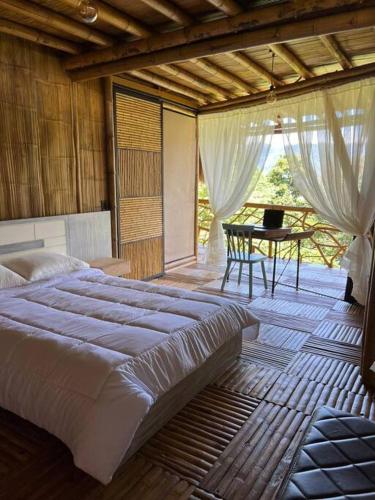a bedroom with a large bed and a table at Casa campestre madremonte in Villeta