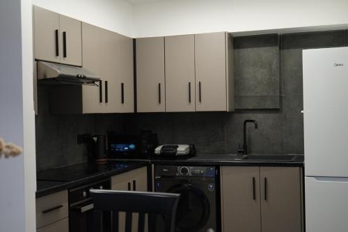 a kitchen with white cabinets and a dishwasher at Lazuli Urban Luxury -2 bedroom with Pool in Larnaka