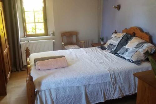 une chambre avec un grand lit avec des oreillers dessus dans l'établissement Maison typique normande- Le Gite du chat bleu, à Illeville-sur-Montfort