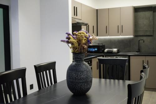 a vase with flowers sitting on a table in a kitchen at Lazuli Urban Luxury -2 bedroom with Pool in Larnaka
