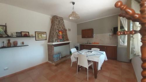 a kitchen and dining room with a table and a fireplace at Isuedda in Marrùbiu