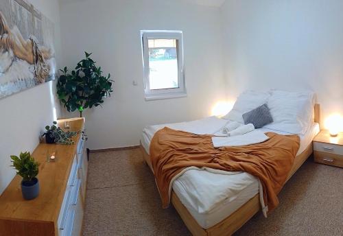 a bedroom with a bed with two lamps and a window at Bungalov Jozef in Liptovská Teplička