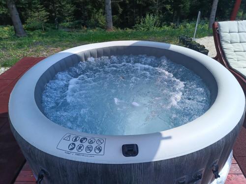 a hot tub filled with water on a patio at Chechar Inn Zlatar in Nova Varoš