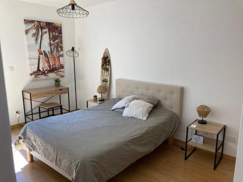 米洛Chambre dans villa cosy avec terrasse的一间卧室配有一张带两张桌子和一盏灯的床