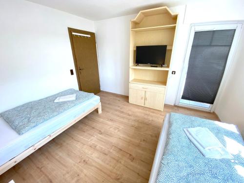 a bedroom with a bed and a tv in it at IV Apartment 12 Personen - Monteurzimmer - Ferienwohnung - Kronwieden in Loiching