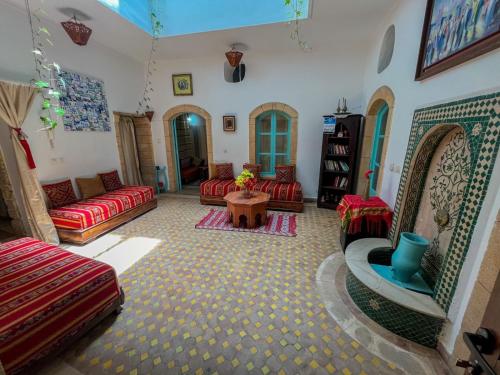 a living room with red couches and a table at Riad Dar in Essaouira