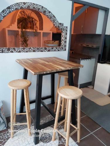 - une table en bois et deux tabourets dans la cuisine dans l'établissement CAEN PORT CENTeR, à Caen