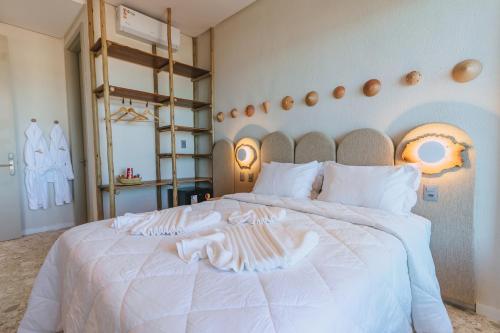 a bedroom with a white bed with a towel on it at JANGA HOTEL BOUTIQUE in Maragogi