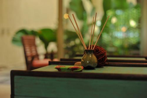 a table with a vase with sticks on it at Camfusion House in Hoi An