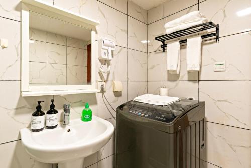 a bathroom with a sink and a toilet and a mirror at Guangzhou Manhattan International Apartment Zhengjia Branch-FREE SHUTTLE BUS FOR CANTON FAIR in Guangzhou