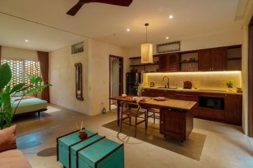 a kitchen with a table and a sink in a room at Camfusion House in Hoi An