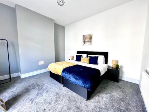 Outdoor Patio, Near Stadium Of Light, Refurbished في Monkwearmouth: غرفة نوم بسرير كبير وملاءات زرقاء وصفراء