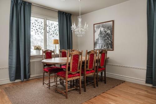 a dining room with a table and chairs and a chandelier at Merlo Slott in Timrå