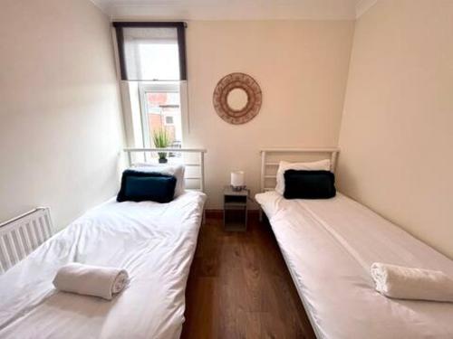 two twin beds in a room with a window at Enjoy A Spacious 3 Br Home in Gateshead