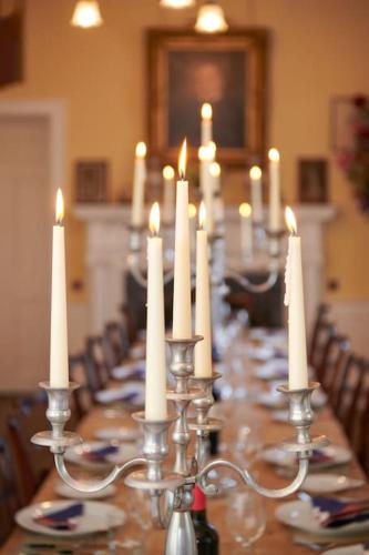 a long table with white candles on top of it at Idyllic 12 bedroom Country Home in Forres