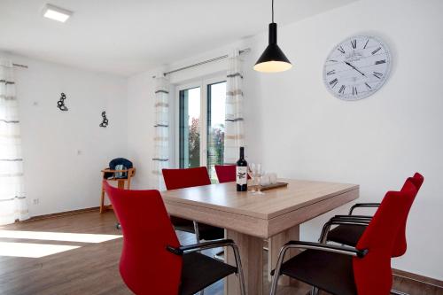 a dining room with a wooden table and red chairs at Ferienwohnung im Allgäu - Biber 1 in Leutkirch im Allgäu