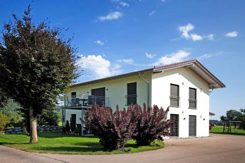 a white house with a tree in front of it at Ferienwohnung im Allgäu - Biber 1 in Leutkirch im Allgäu