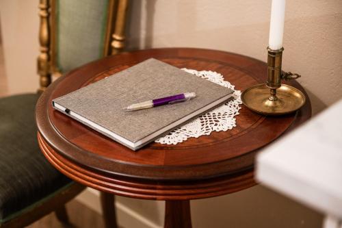 a notebook and a pen on a table with a candle at Merlo Slott in Timrå
