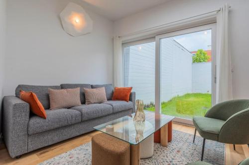 un salon avec un canapé et une table en verre dans l'établissement Maison 4 chambres et 2 SDB, avec jardin, à Lambersart