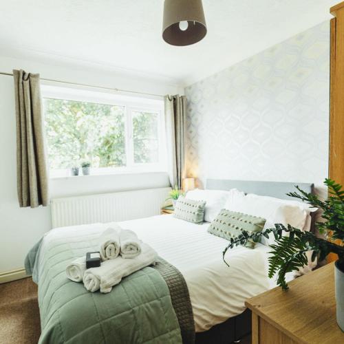 a bedroom with a bed with towels on it at Birchwood Cottage with hot tub in Valley