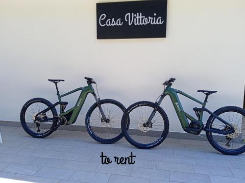three bikes are parked next to a wall at Casa Vittoria Guest House in Romano D'Ezzelino