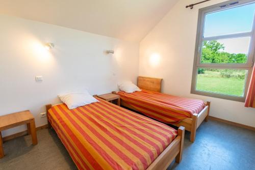deux lits dans une chambre avec une fenêtre dans l'établissement Gîte Gîtes de France 3 épis 4/6 personnes au Falisson, à Saint-Beauzile