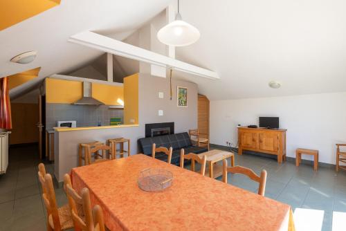 un salon avec une table, des chaises et un canapé dans l'établissement Gîte Gîtes de France 3 épis 4/6 personnes au Falisson, à Saint-Beauzile