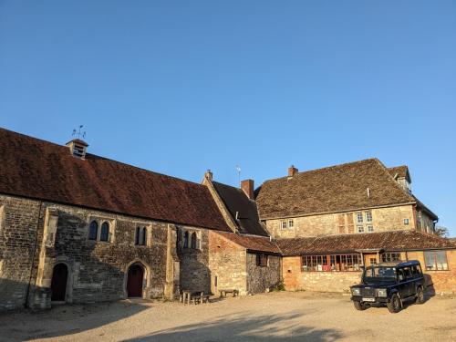 an old building with a truck parked in front of it at Large Manor House near Bath in Trowbridge