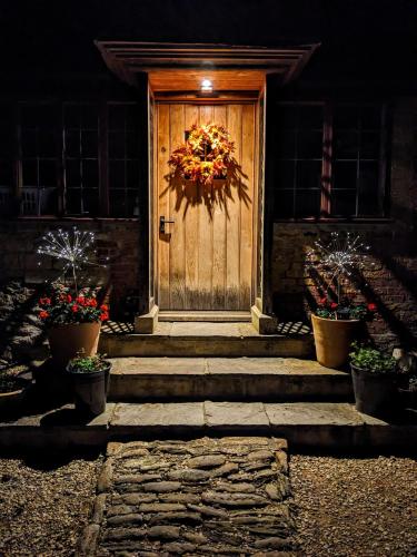 a wooden door with a wreath on it at Large Manor House near Bath in Trowbridge