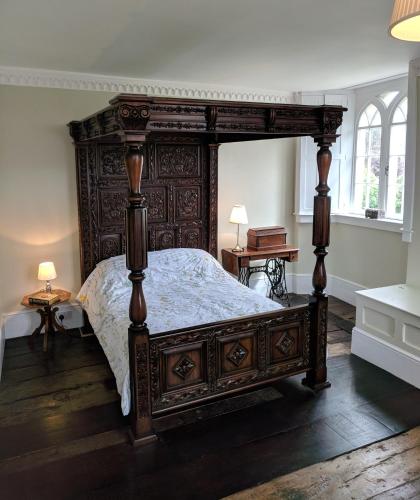 a bedroom with a large wooden bed in a room at Large Manor House near Bath in Trowbridge