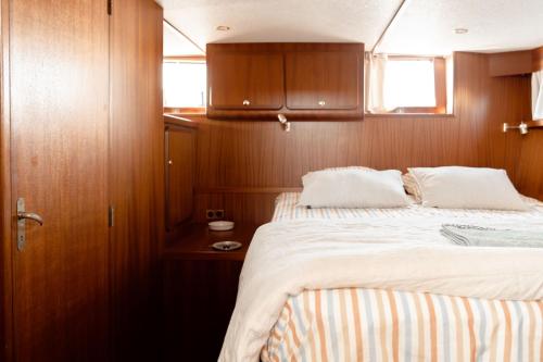 - une chambre avec un lit dans un bateau dans l'établissement Hébergement insolite en demi-pension et excursion gastronomique en bateau, à Bouzigues