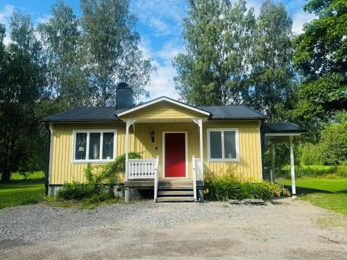 a yellow tiny house with a red door at Merlo Slott in Timrå
