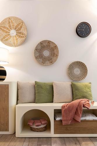 a living room with a couch and clocks on the wall at The Originals City, Hôtel Bristol, Le Puy-en-Velay in Le Puy en Velay