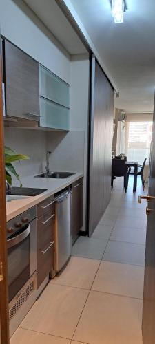 a kitchen with stainless steel appliances and a table at Departamento frente Monumento Rosario in Rosario
