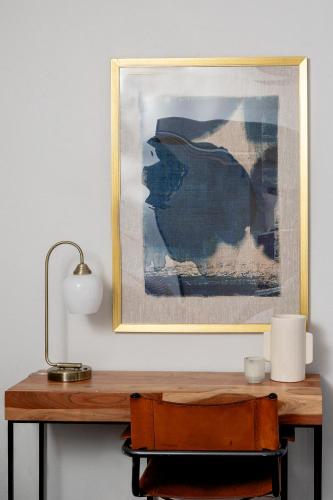 a picture on a wall above a table with a lamp at High design & coziest comforts in Gainesville