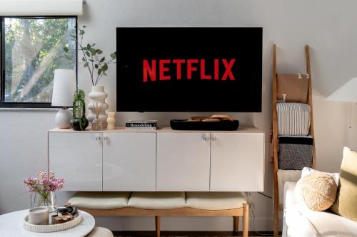 a living room with a netflix sign on the wall at High design & coziest comforts in Gainesville