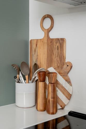 a bunch of wooden utensils sitting on a shelf at High design & coziest comforts in Gainesville