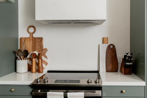 a kitchen with a stove top oven next to a counter at High design & coziest comforts in Gainesville